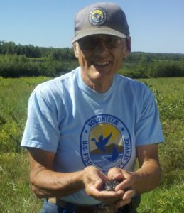 Carl holding a purple martin chick for banding.
